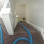 Carpet cleaning hoses run up the steps to 2nd floor